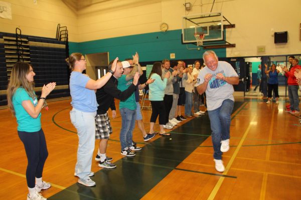 Original Raven Ed Rosin, who has taught math at Auburn Riverside since the school opened in 1997, dances through a crowd of teachers during the Raven Walk in the gymnasium last Friday. Rosin is one of seven Ravens who is retiring this year.